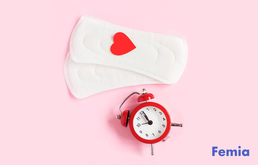 Two menstrual pads with a red heart on top, alongside a red alarm clock.