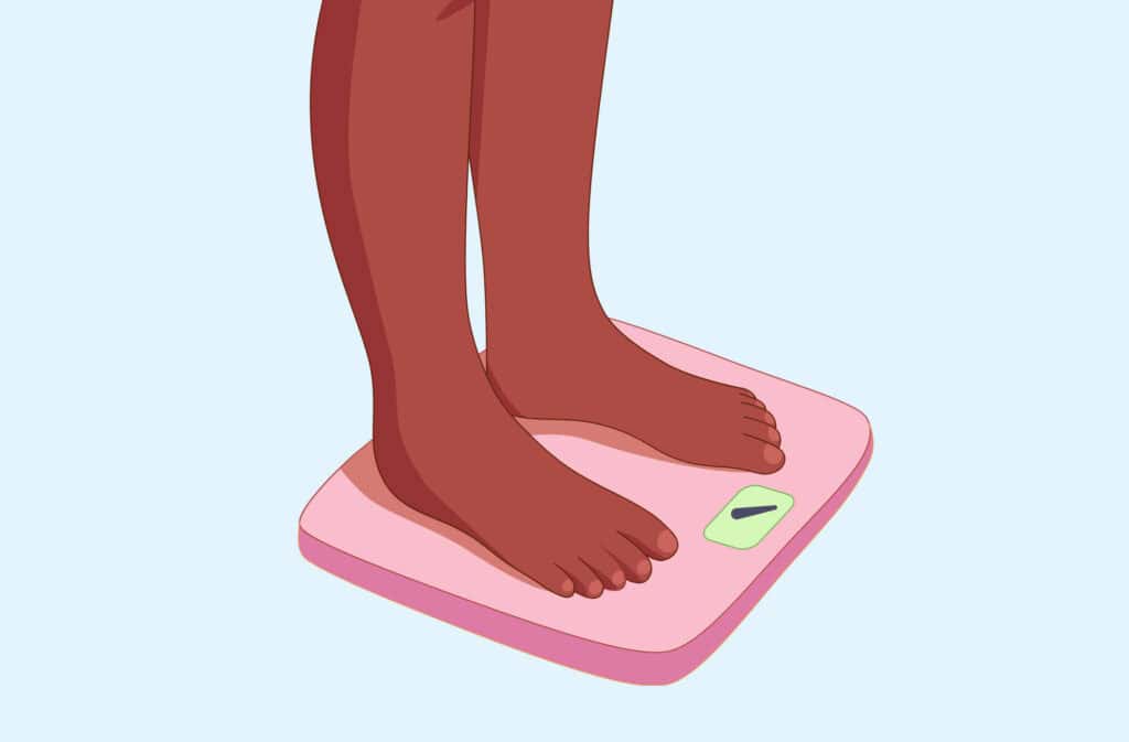 A person's feet on a scale, symbolizing weight loss during pregnancy.