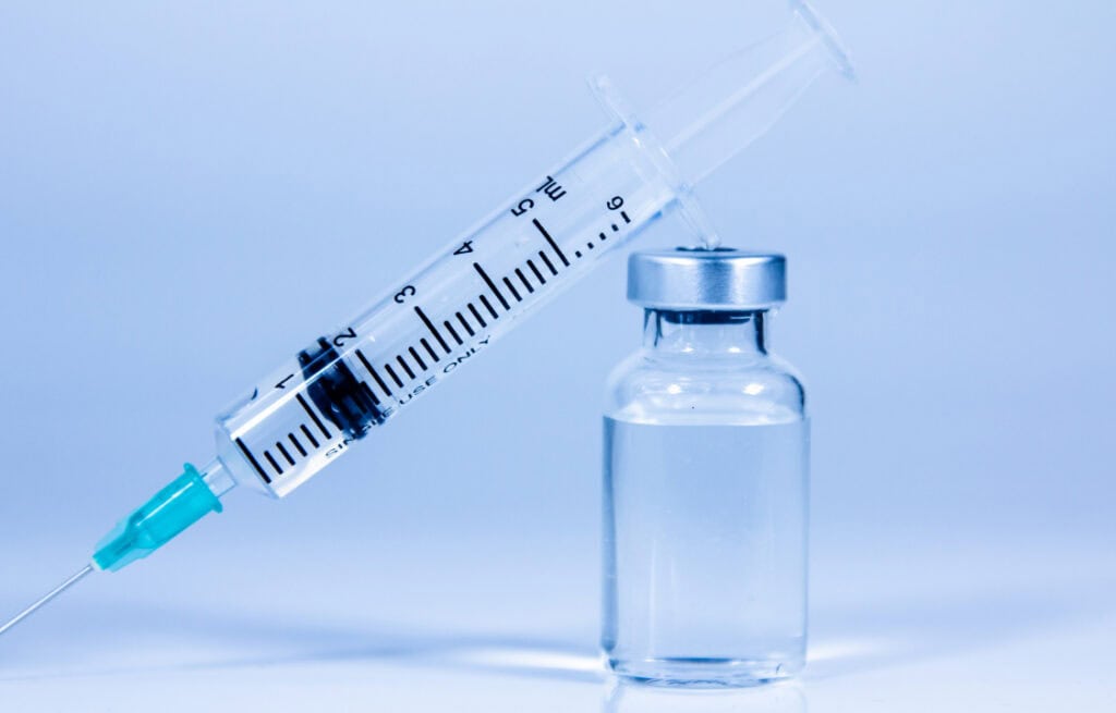 Close-up of a syringe and vial, representing latest HIV treatment.