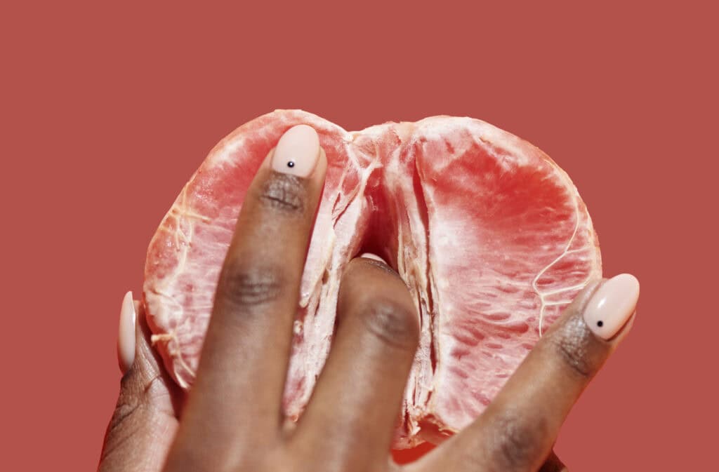 An image of a woman's hand touching a grapefruit, representing vabbing.