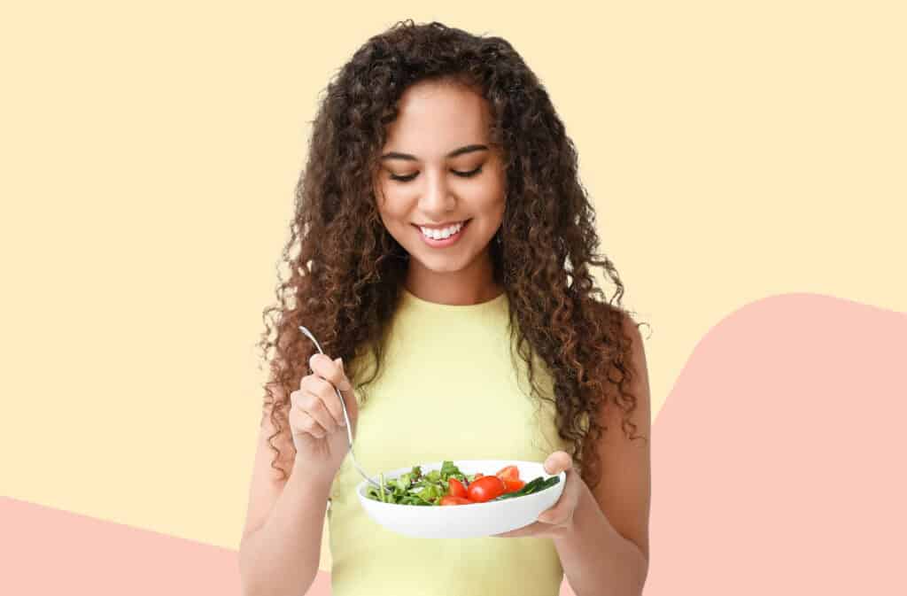 A photo of a woman eating healthy food representing cycle syncing diet.