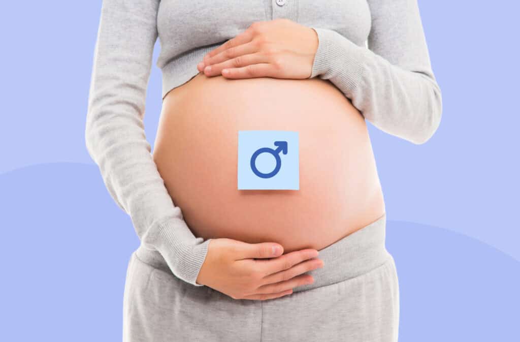 A photo of a pregnant belly with a sticker on representing the question How to conceive a boy?