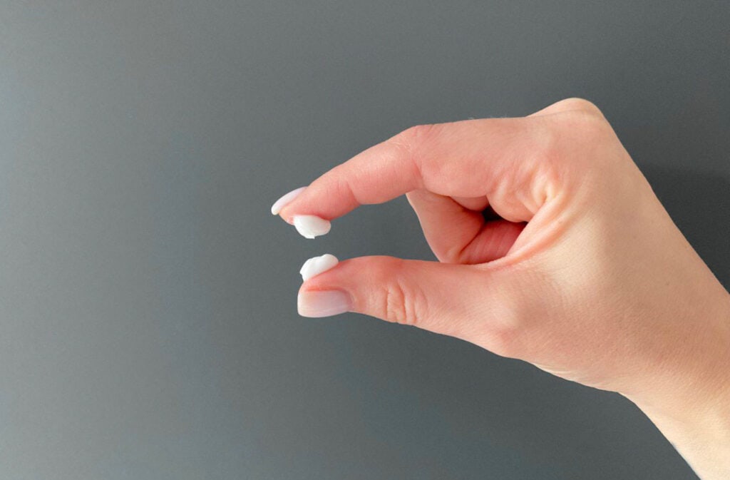 A photo of a hand stretching the milky white discharge.