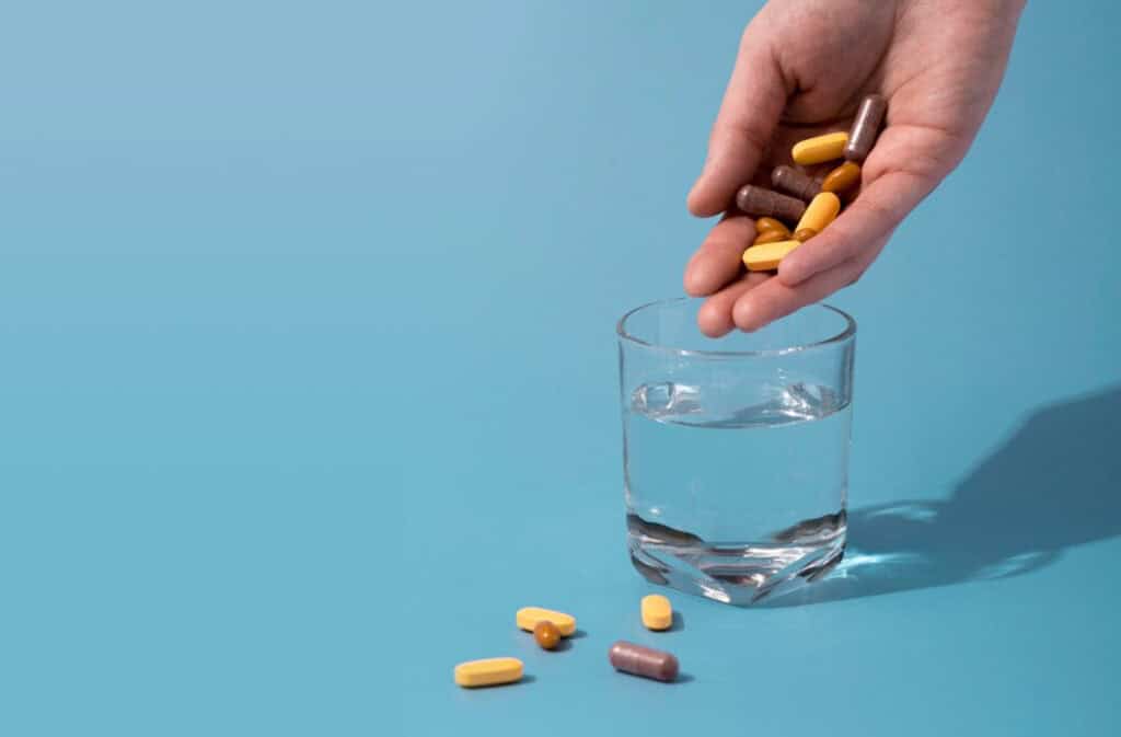 A photo of a gand dropping pills into a glass of water representing PCOS supplements Viewers of this file can see comments and suggestions.