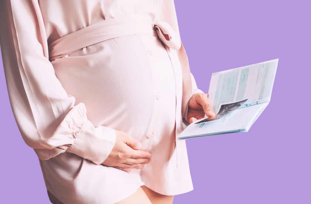 A photo of a pregnant woman holding a notebook with a birth plan checklist.