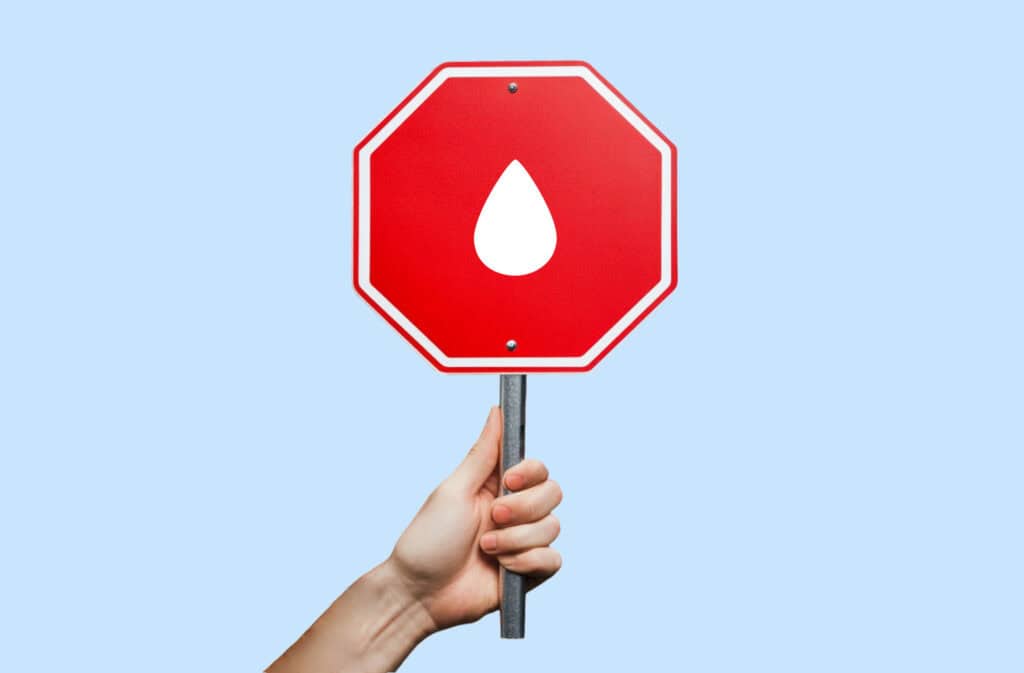 A photo of a hand holding a stop sign, representing how to stop your period Viewers of this file can see comments and suggestions.